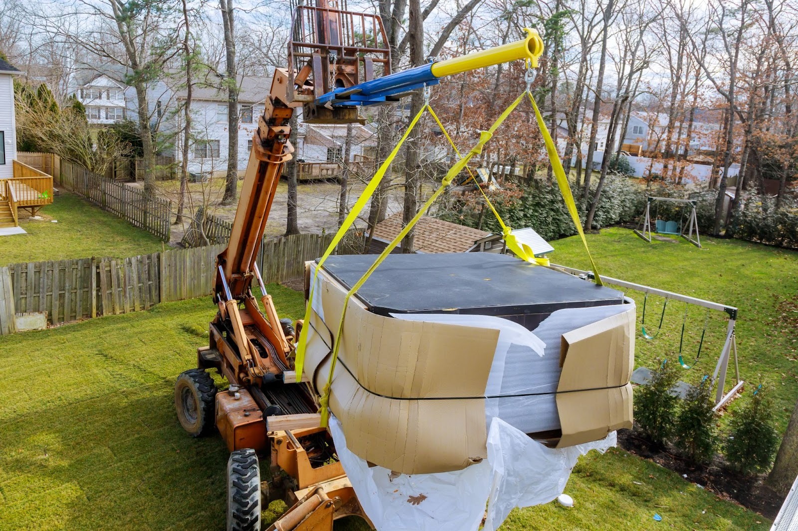 A crane hoists up a hot tub during a move.